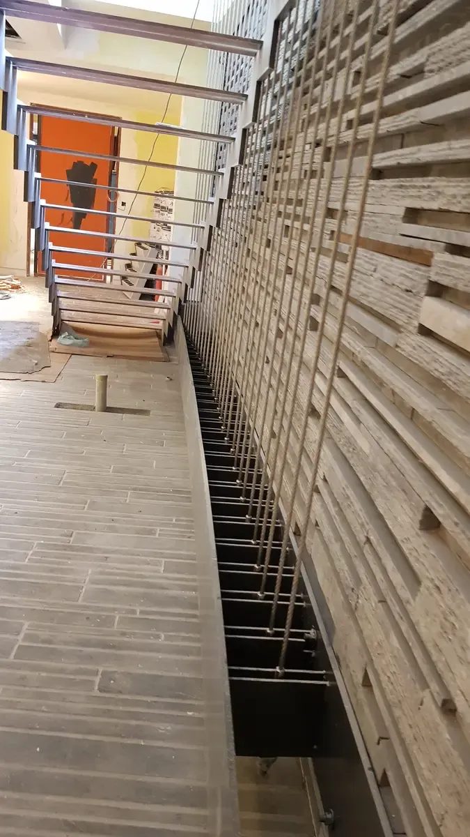 Full height vertical cable balustrade running the depth of a stairwell void