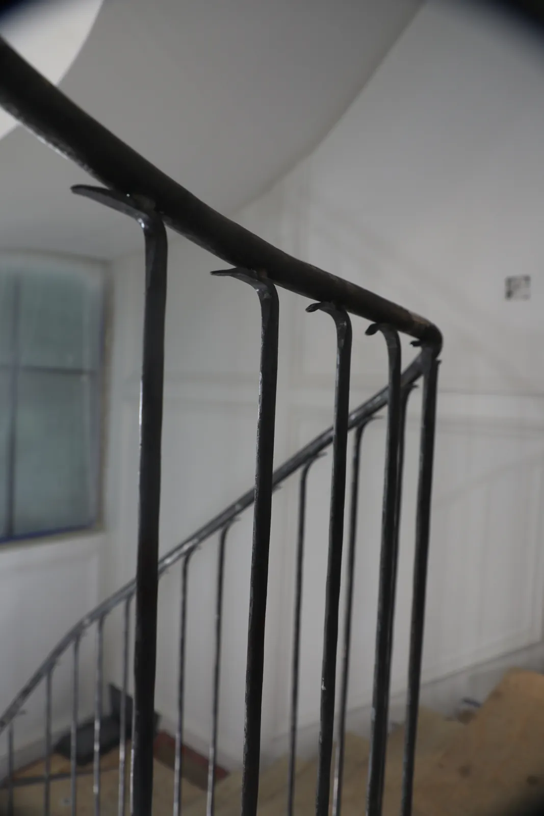 Close view of a curved steel guardrail showing evenly spaced round bars following the radius