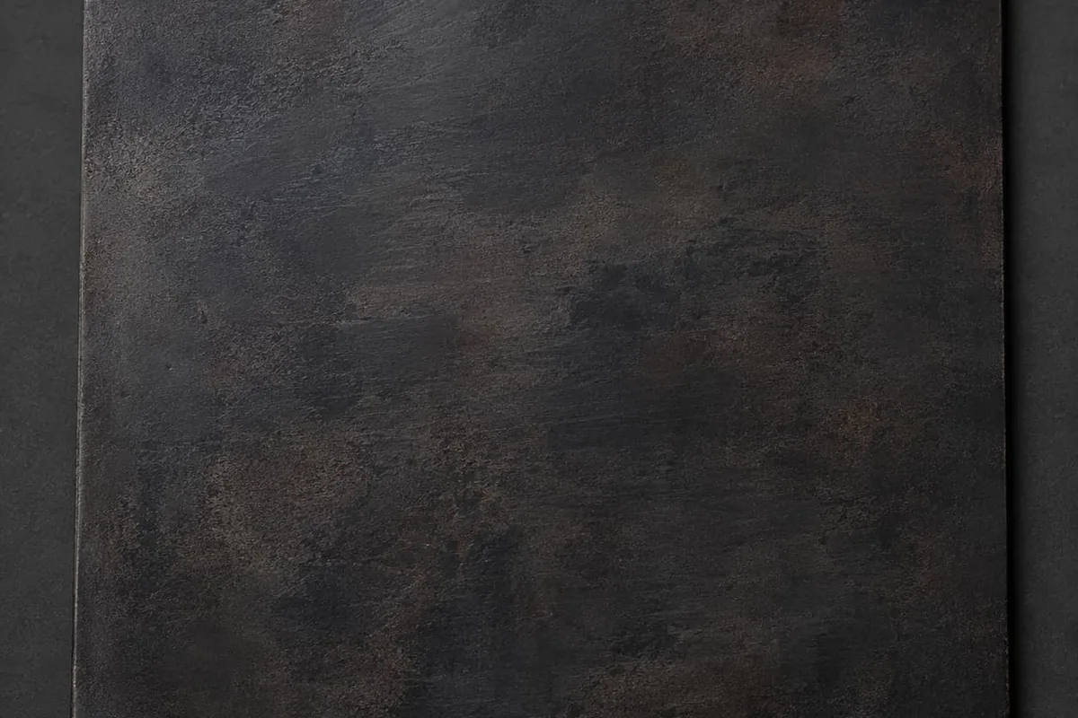 Steel with a matte black chemical patina showing cloudy tonal variation