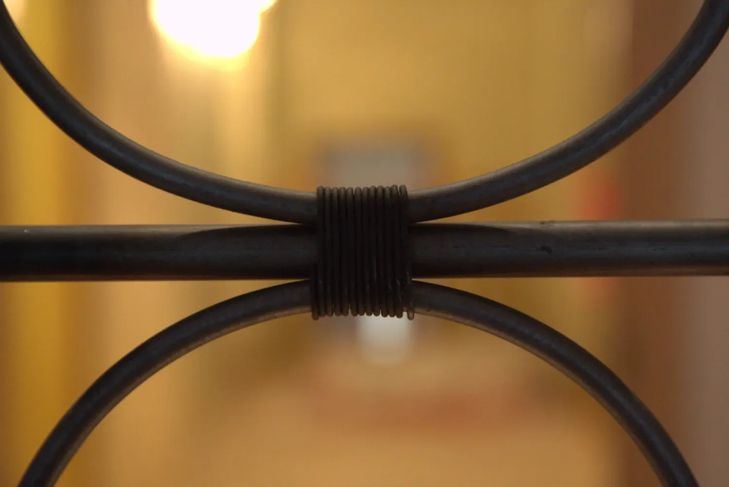 Close view of a forged collar wrapped around the junction of two round bars