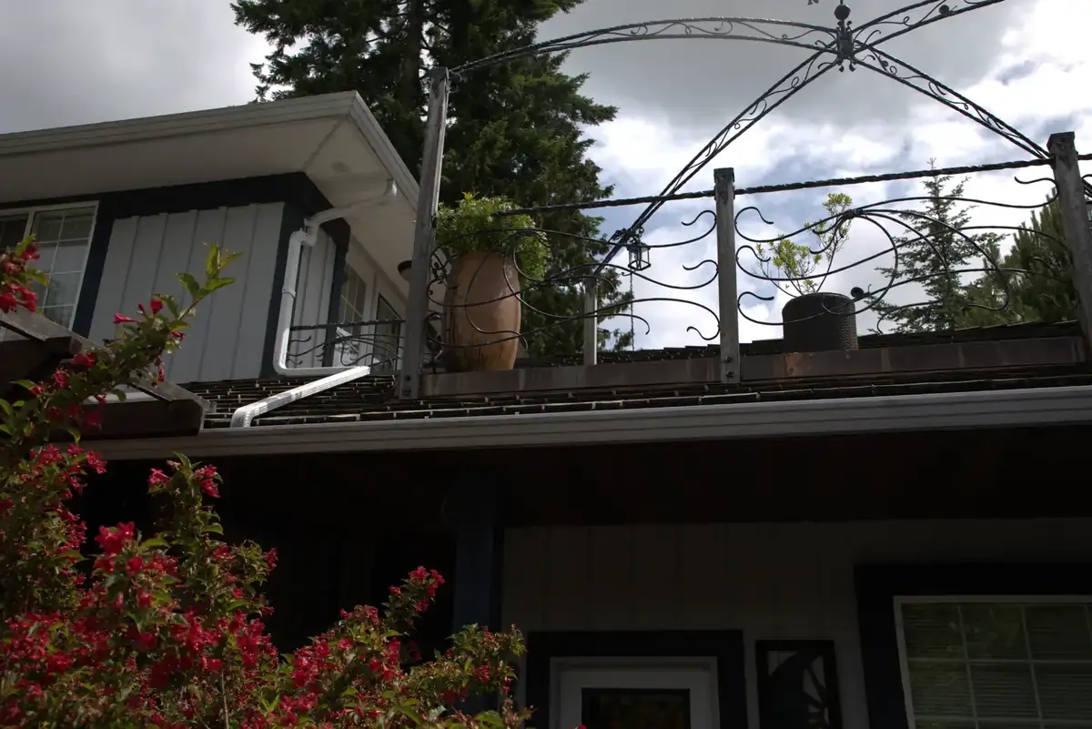 Forged deck railing with scrolled infill and an arched frame above, on a raised deck