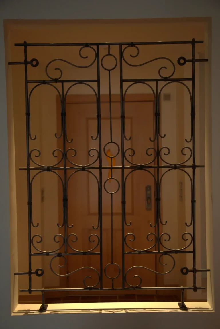 Hand forged decorative steel screen set into an interior wall opening
