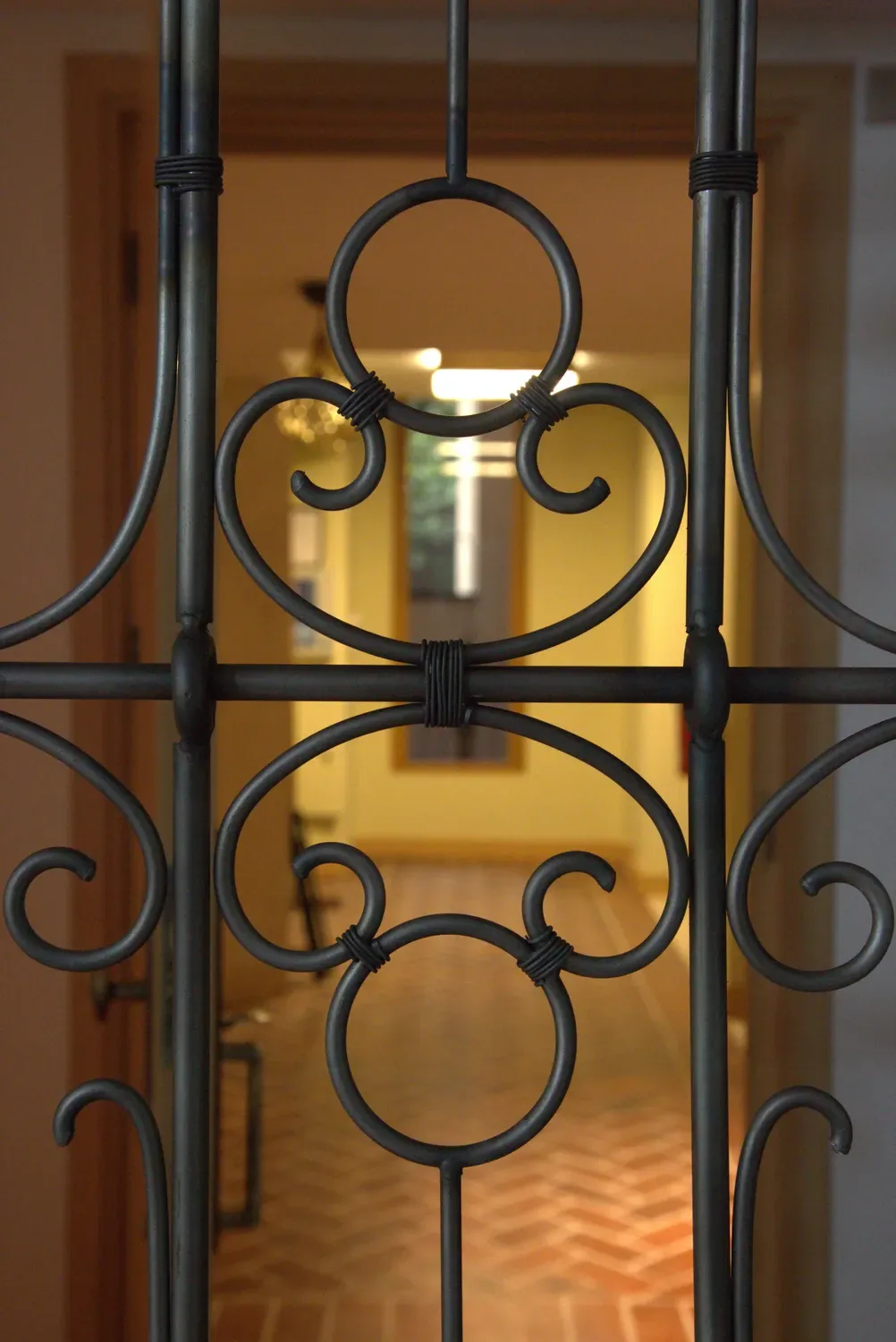 Forged circle and scroll motif at the centre of a screen bay