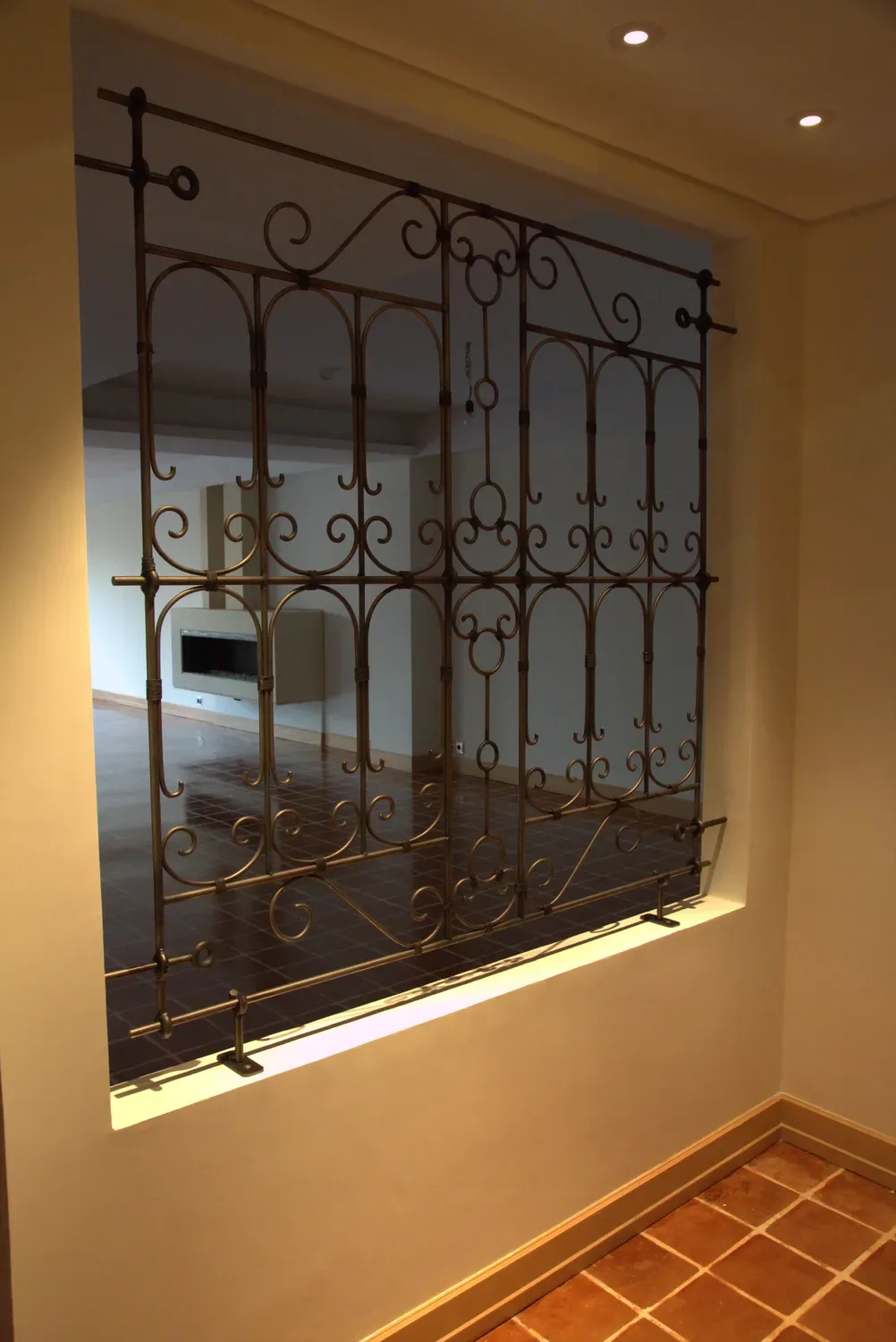 Angled view of a forged screen fitted into the thickness of an interior wall opening