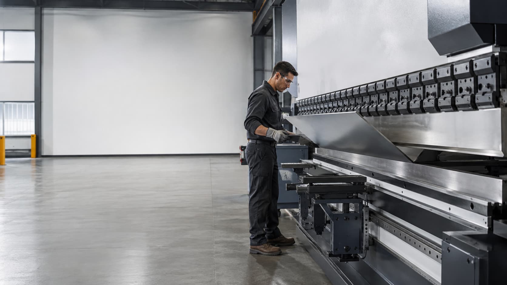 Sheet metal panel being formed on a press brake in a fabrication shop