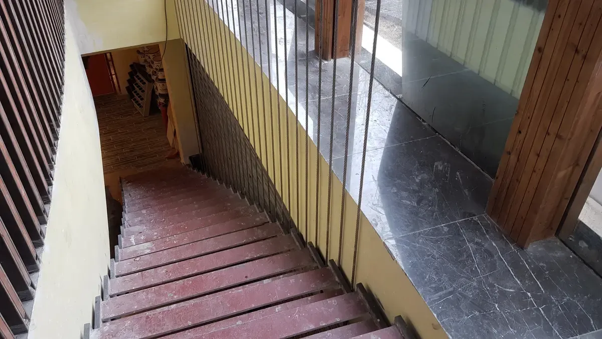 Open riser steel stair with a vertical cable balustrade along the open side