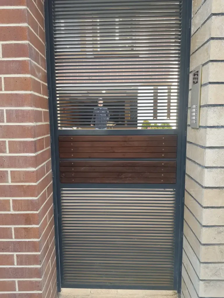 Vertical bar entrance gate with a timber slat panel