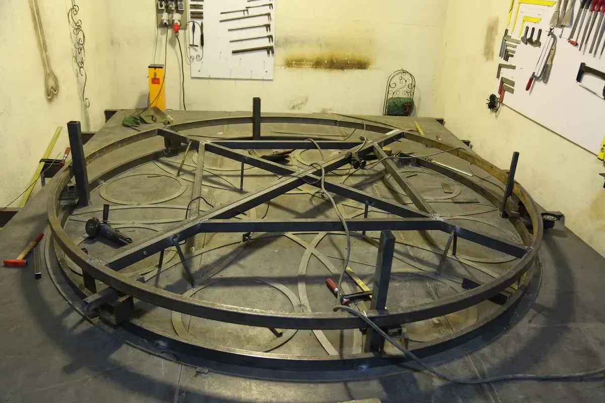 Rolled steel ring frame with radial and cross bracing, set up on the shop floor during assembly