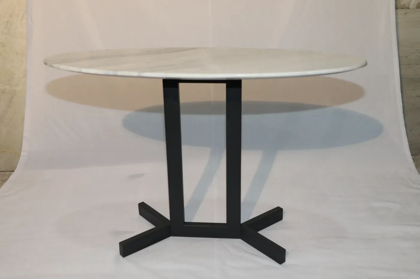 Side view of the fabricated steel table base showing the open rectangular frame and cross foot