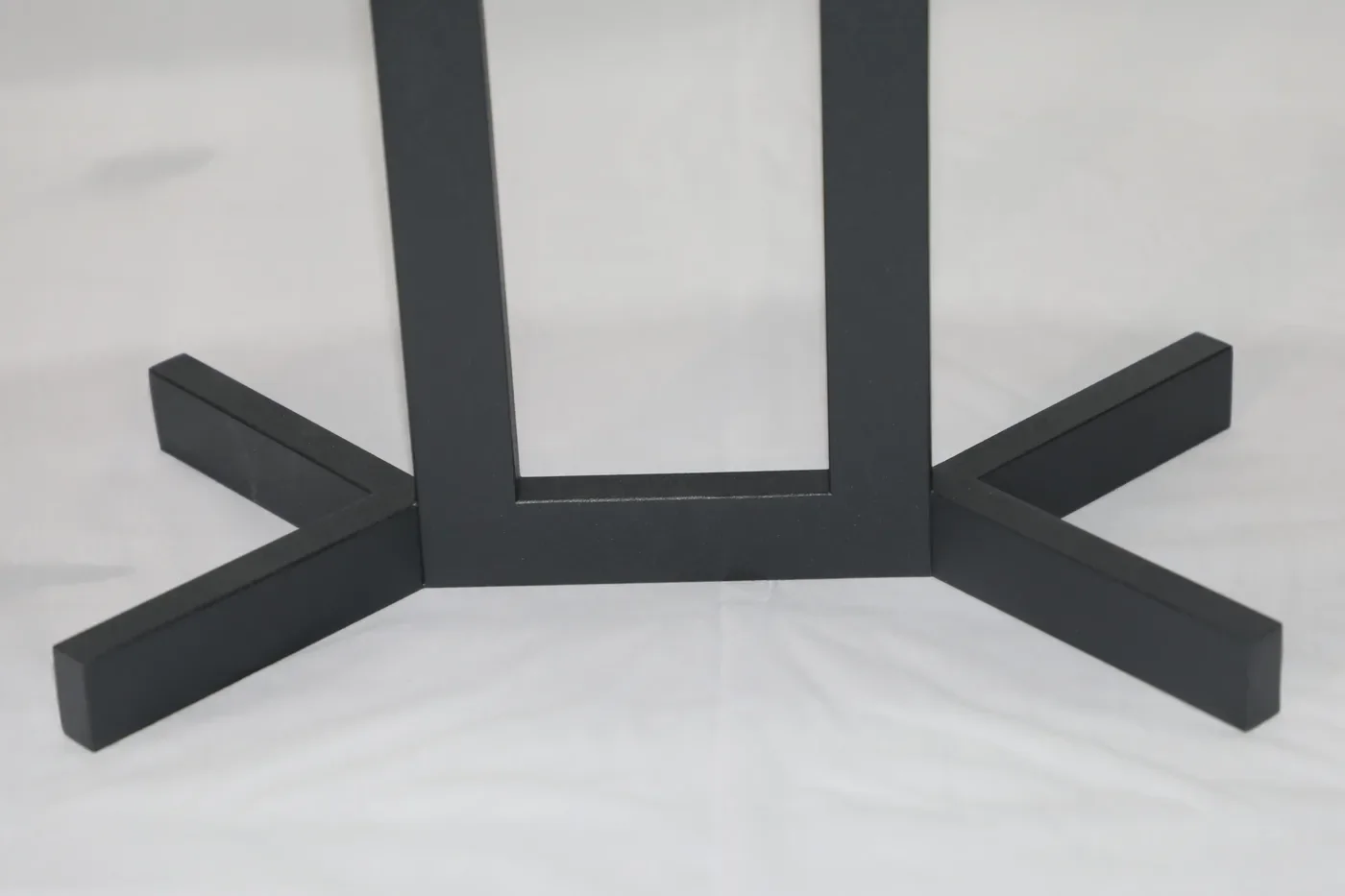 Detail of the four-arm cross foot welded to the base of the steel frame, welds dressed flush