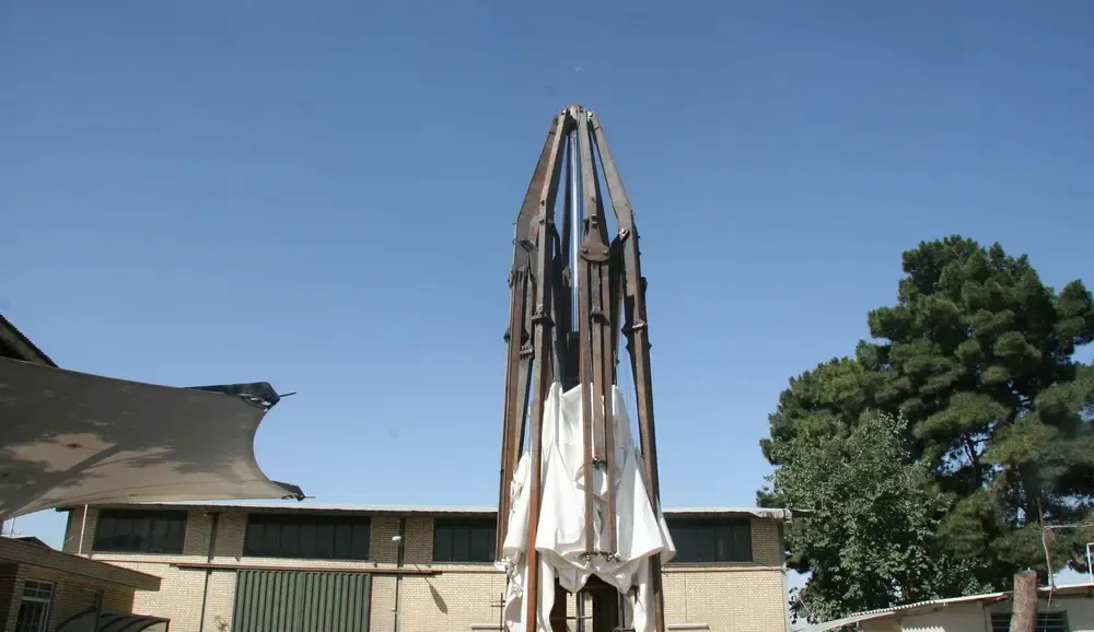 The same umbrella closed, with the folding steel arms upright and the fabric gathered against the mast