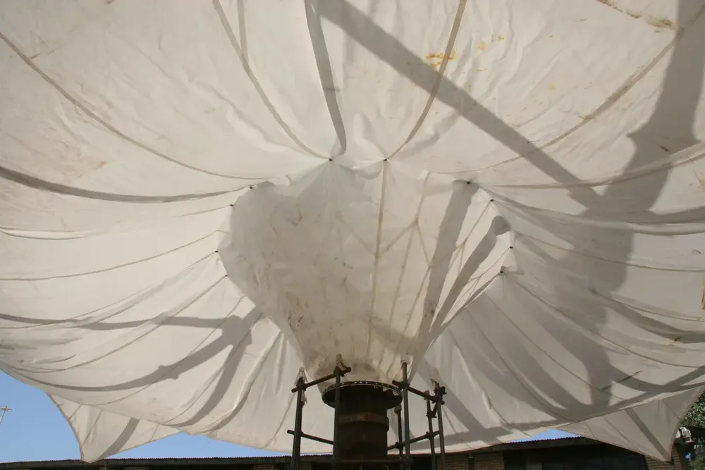 Underside of the tensioned fabric canopy showing the radial seams and reinforcement lines