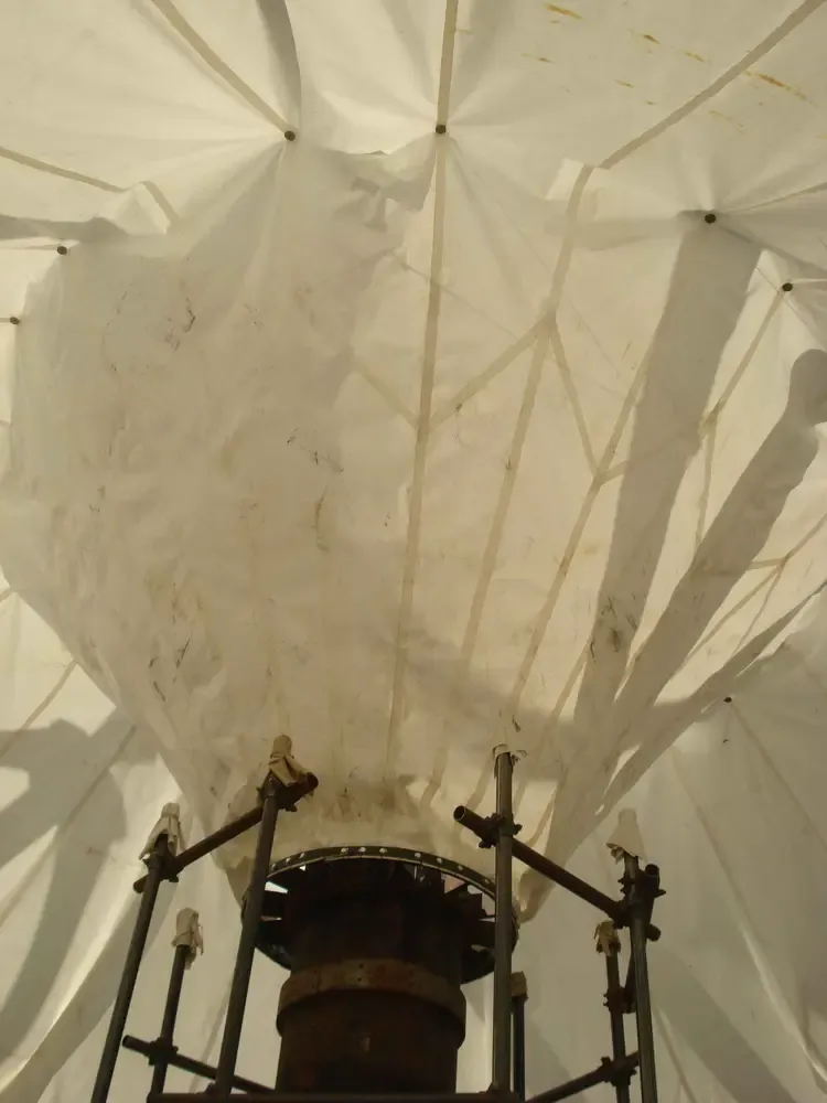 Mast head ring with the radial arms fanning out under the fabric canopy