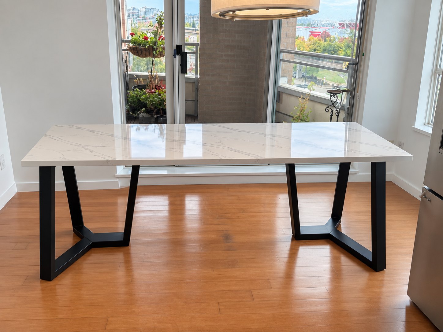 Custom rectangular quartz dining table on a matte black welded steel base, North Vancouver